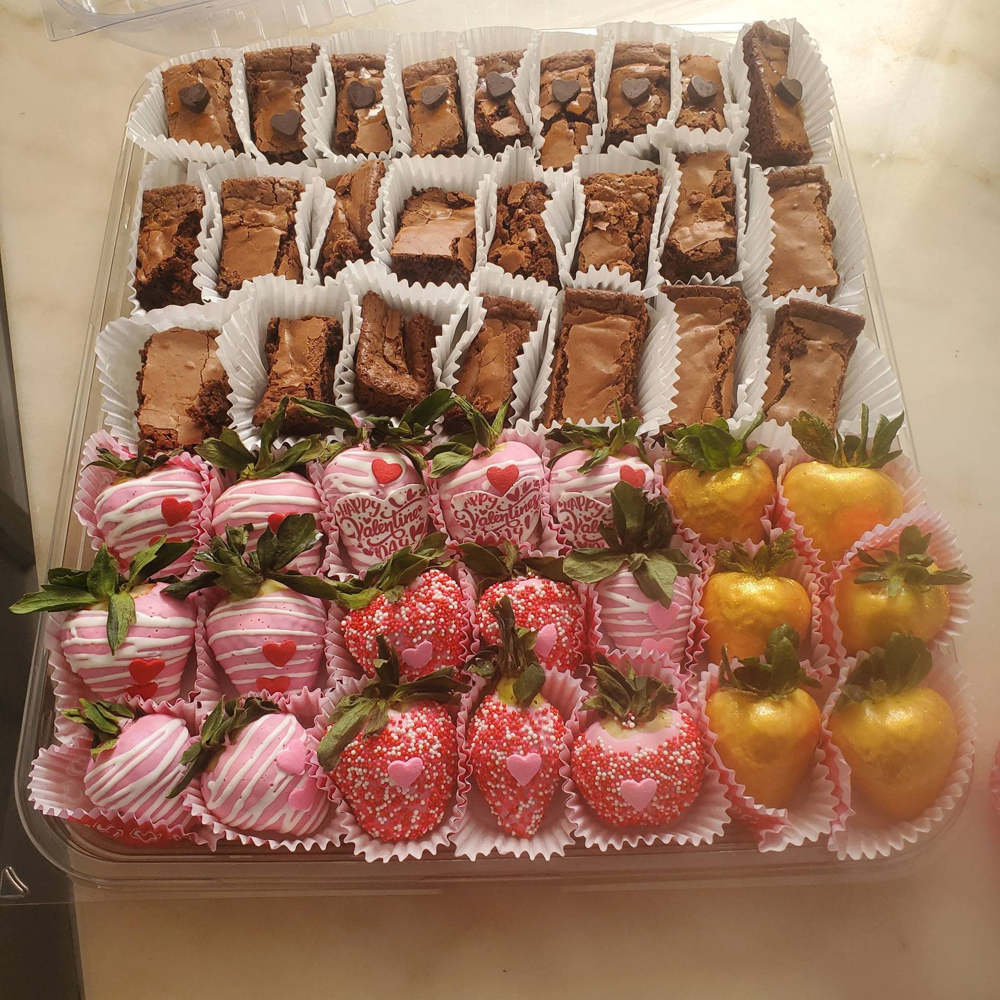 Valentine's Day platter with chocolate brownies and assorted pink, red, and gold chocolate-covered strawberries.