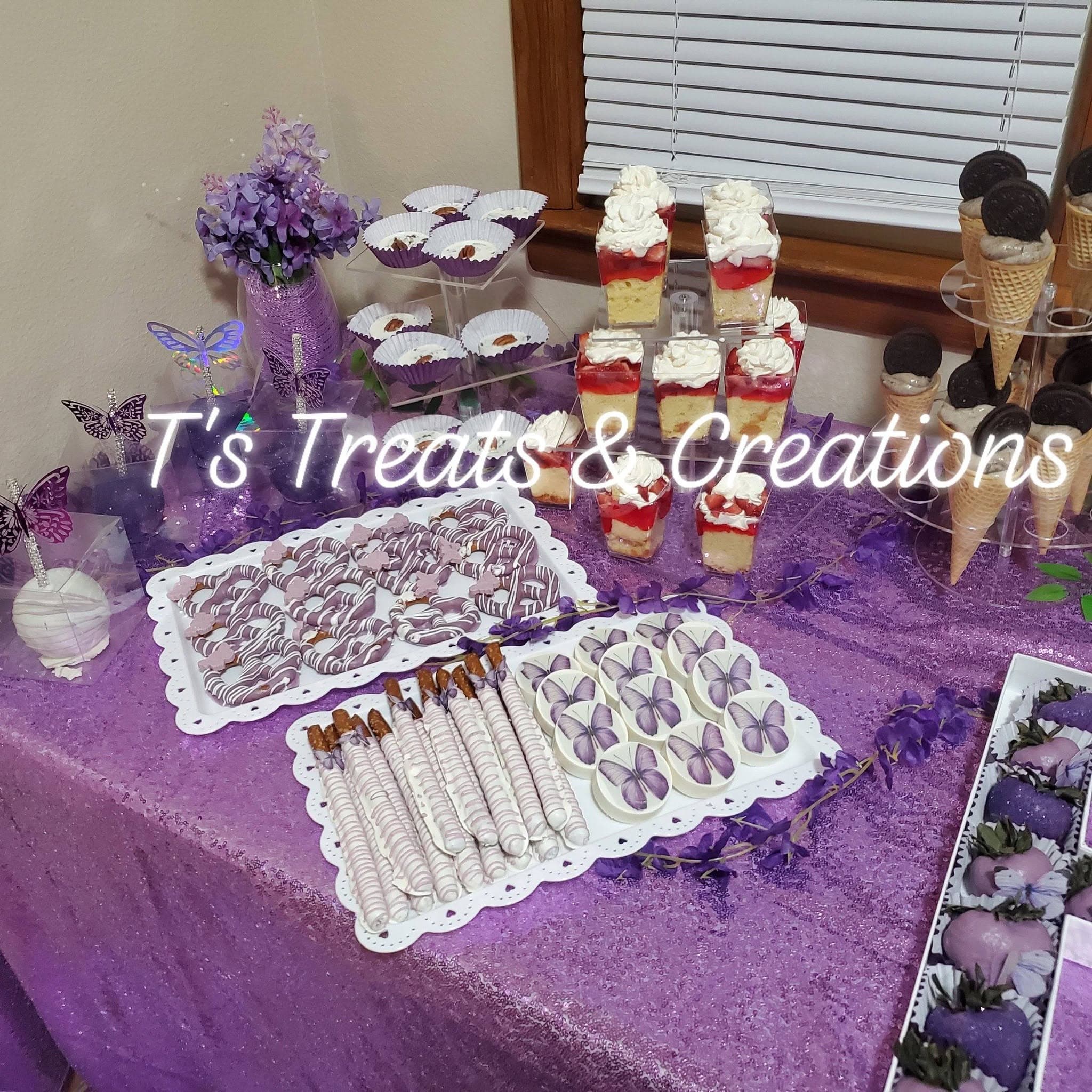 Purple-themed dessert display with butterfly treats, strawberry parfaits, and chocolate-covered pretzels and strawberries.