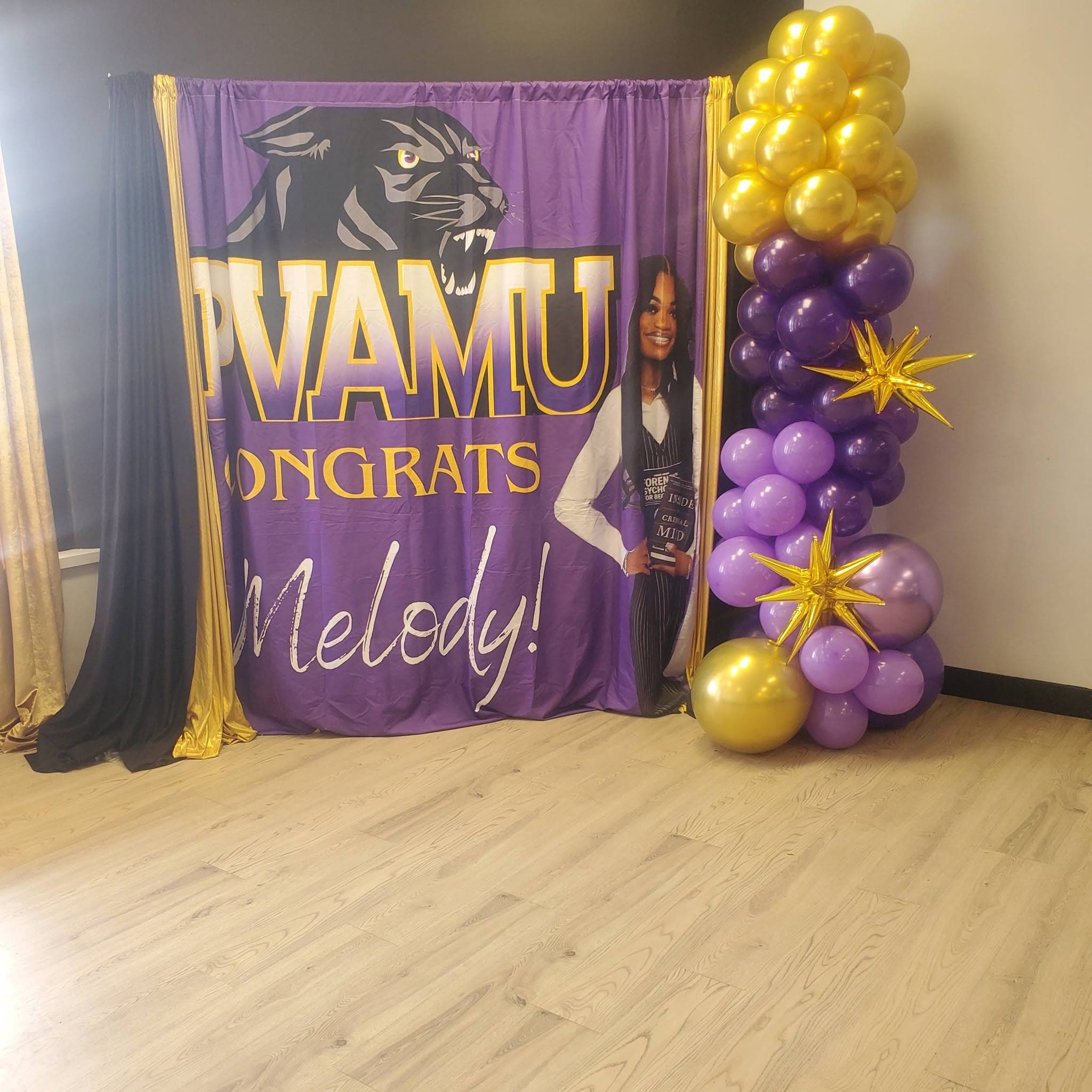 Purple PVAMU graduation backdrop for Melody with a panther logo and gold and purple balloons.