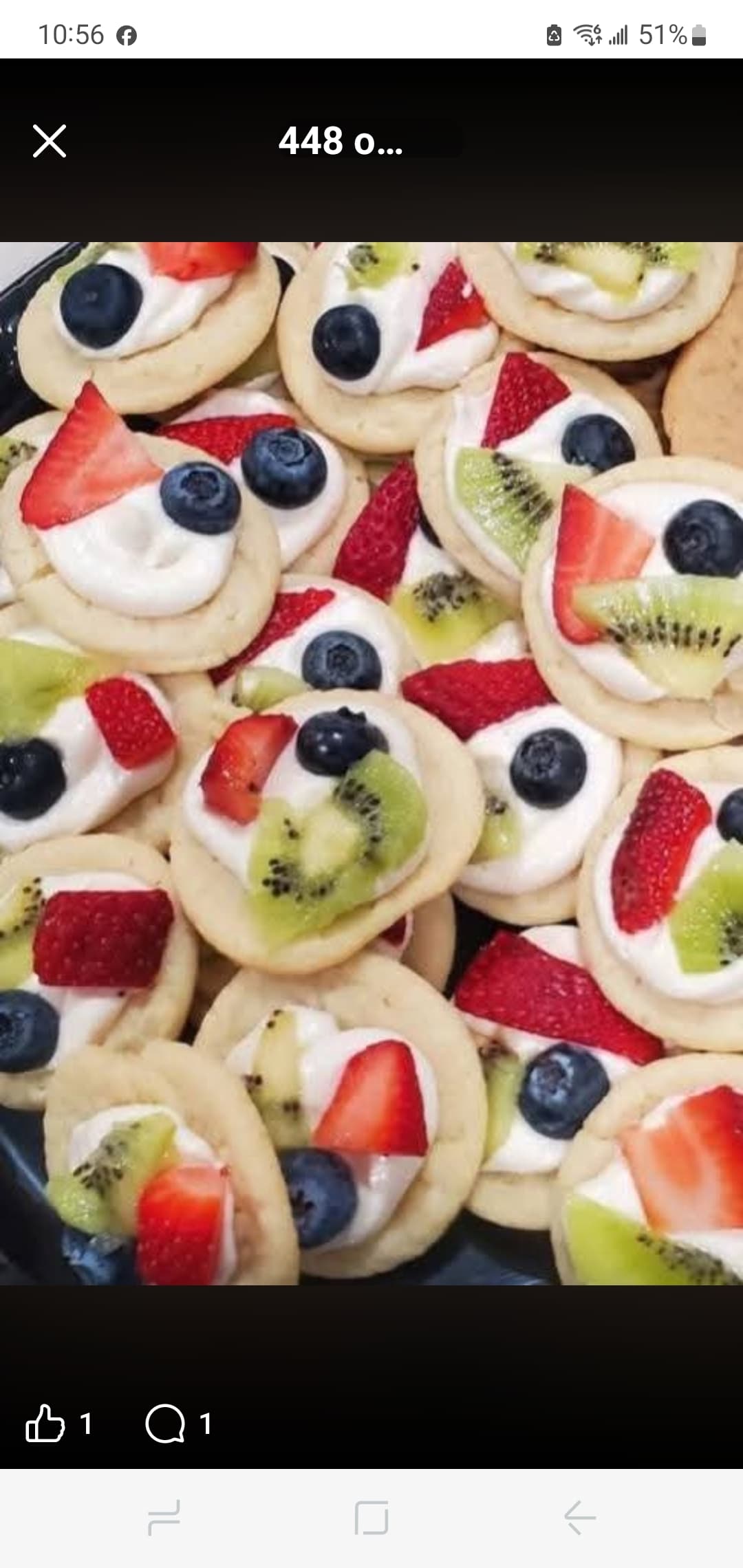 Mini fruit pizzas with white frosting, topped with fresh strawberries, blueberries, and kiwi slices.