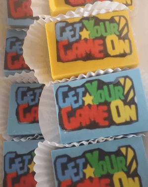 Yellow and blue rectangular chocolates with colorful 'GET YOUR GAME ON' text in paper liners.
