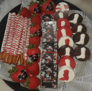 Birthday platter with photo chocolate bars, red-dipped strawberries, drizzled pretzels, and cowboy boot cookies.